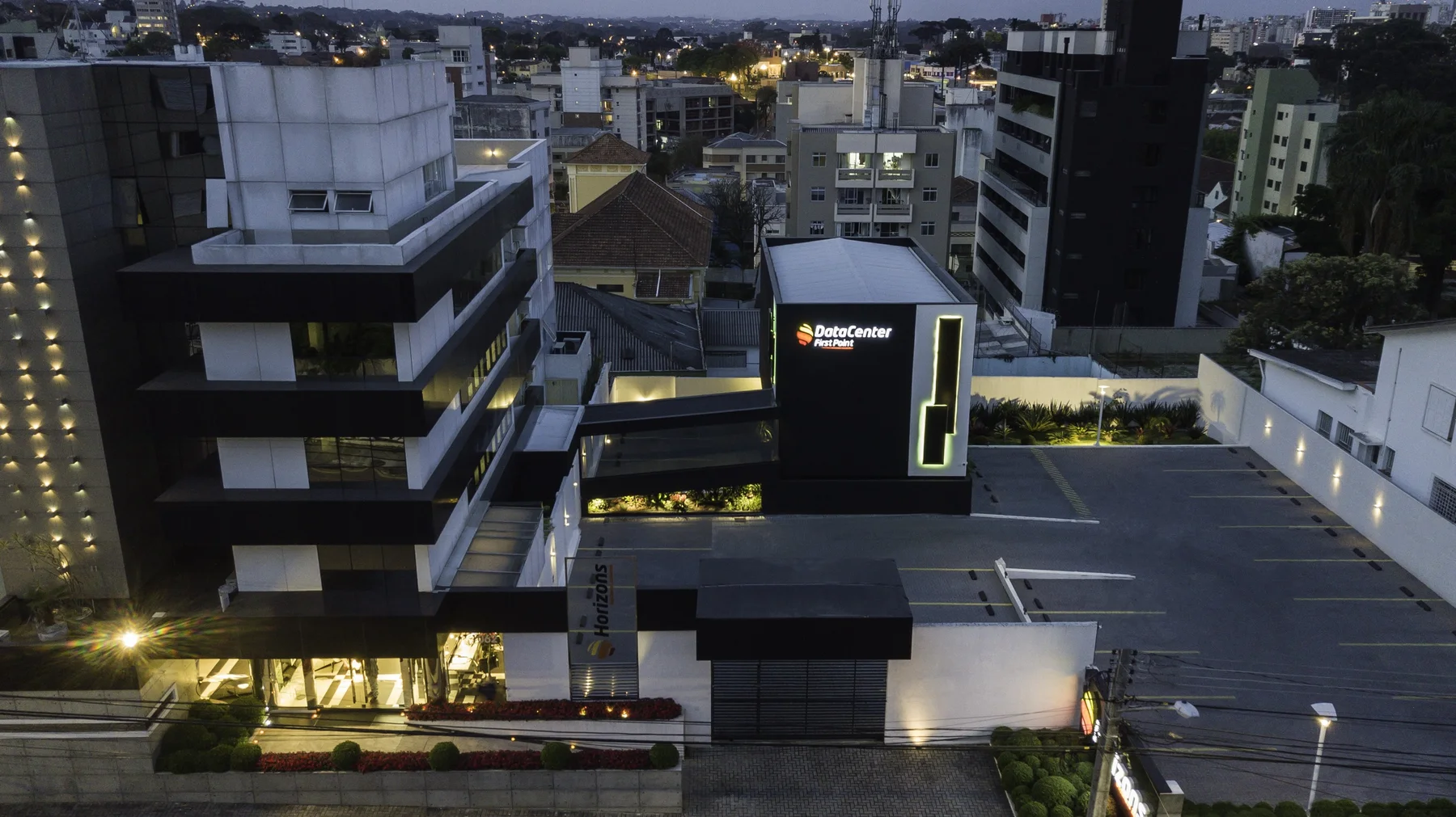 Vista aérea do conjunto, com a passarela suspensa ligando ao edifício existente